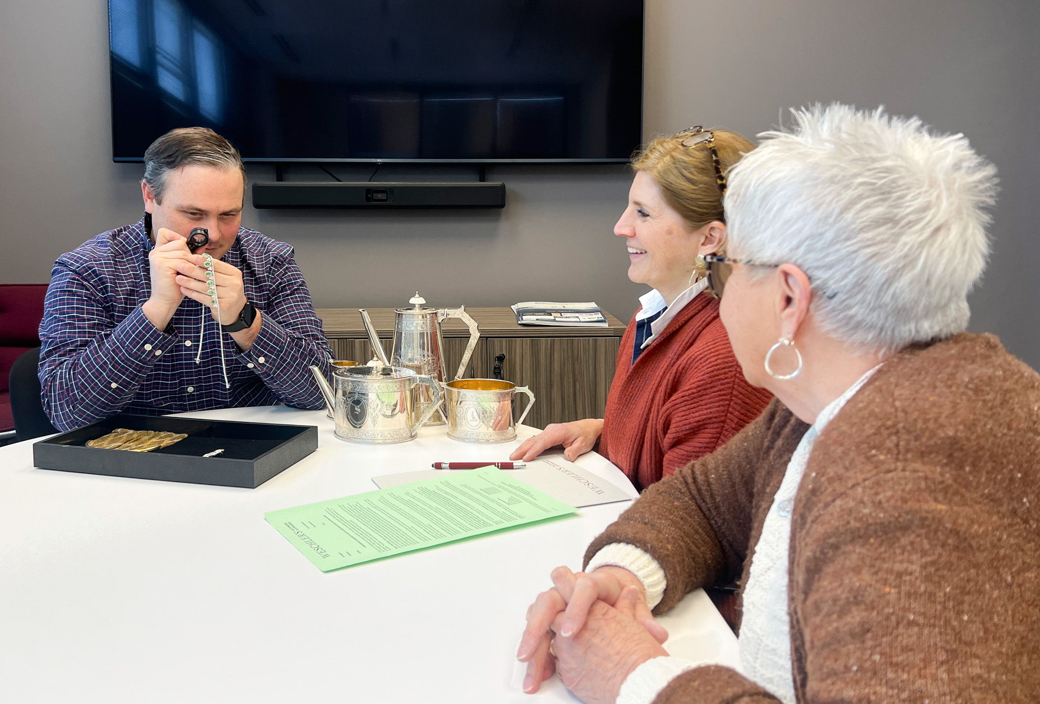 Moyer Auctions Estate Consultation Moyer Auctions team and client reviewing estate items including silver and jewelry during a complimentary consultation