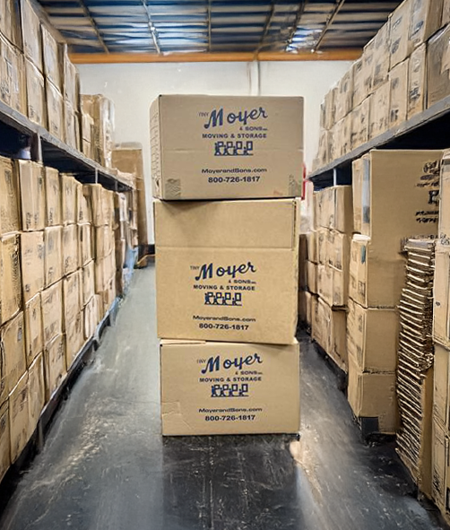 Moyer Auctions Estate Packing and Storage Moyer & Sons branded moving boxes stacked in a secure warehouse facility used for estate and auction item storage