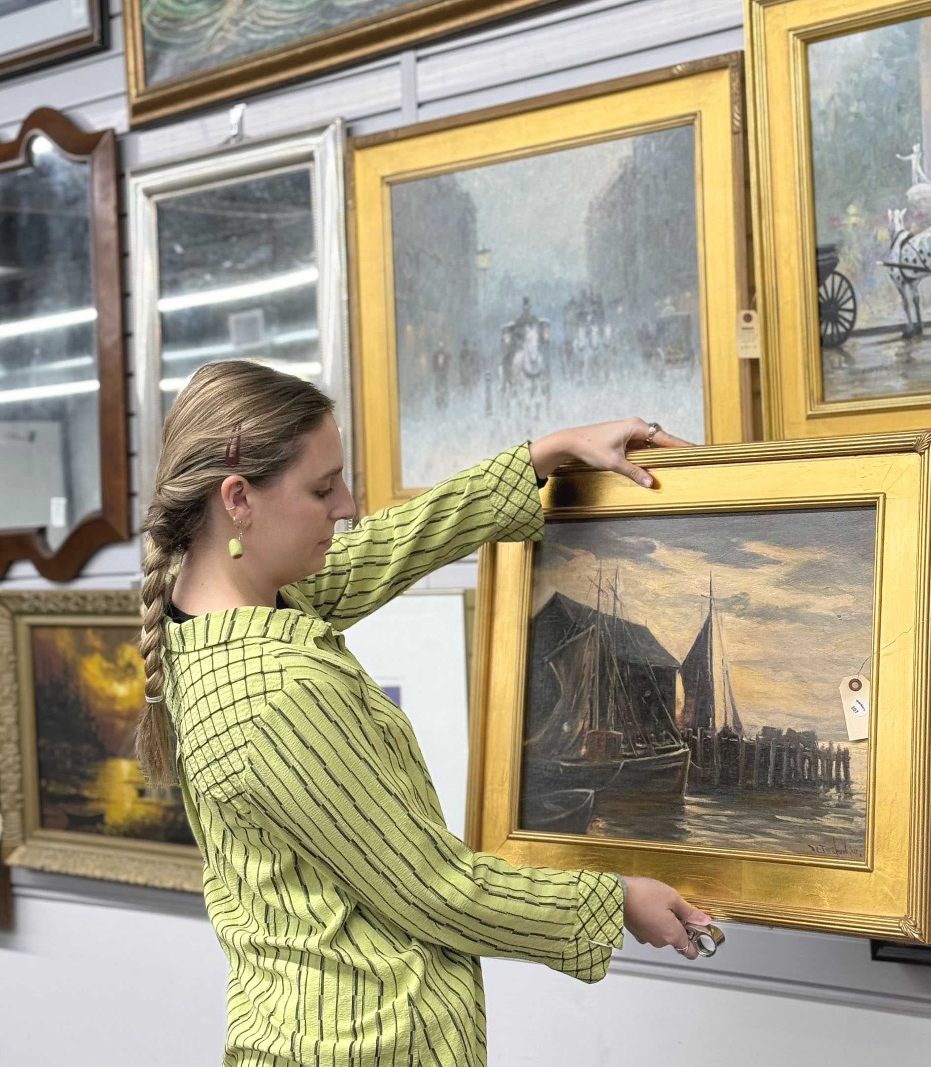 Moyer Auctions Fine Art Evaluation Auction specialist evaluating a framed oil painting as part of a Moyer Auctions estate appraisal